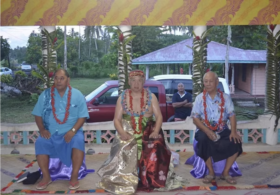 A beautiful scenic view of the Samoan coastline with lush green mountains and clear blue water.